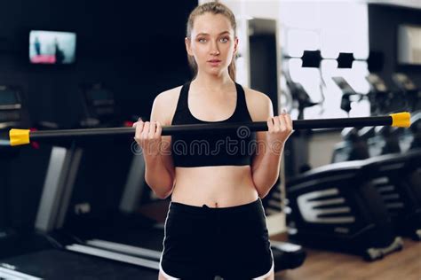 Joven Mujer Deportista De Brunette Haciendo Ejercicio Con Dumbbell En Un Gimnasio Imagen De