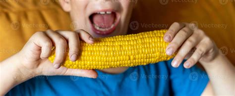 boy opened his mouth to take a bite of boiled corn on the cob 32060688