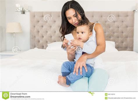 Happy Brunette Holding Her Baby And Using Smartphone Stock Image Image Of Fragility Love