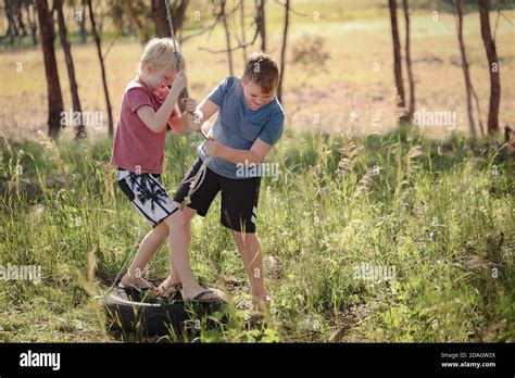 Cute Blonde Brothers Pulling A Rope And Playing Happily In The Park Stock Photo Alamy