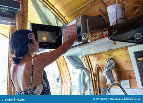 Latina Woman Cooking A Quick Meal In A Microwave Oven In A Country Kitchen Stock Photo Image