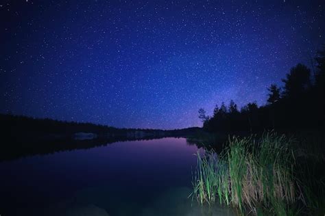 Lago à noite incrível céu estrelado e reflexos na água Externos