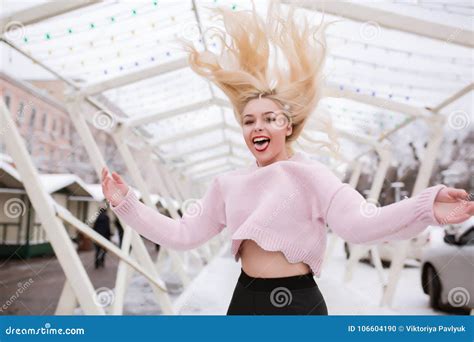 Femme Blonde Positive Avec De Longs Cheveux Dans Le Mouvement Sautant Au St Photo Stock Image