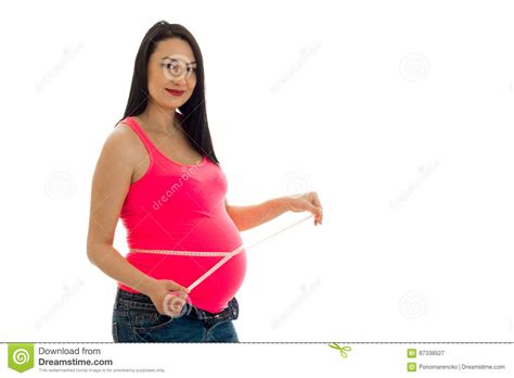 Portrait Of Pregnant Brunette In Pink Shirt Measure Her Belly With Tape And Posing On Camera