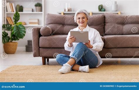 Femme Mature Souriante Utilisant Une Tablette à La Maison Photo stock Image du numérique