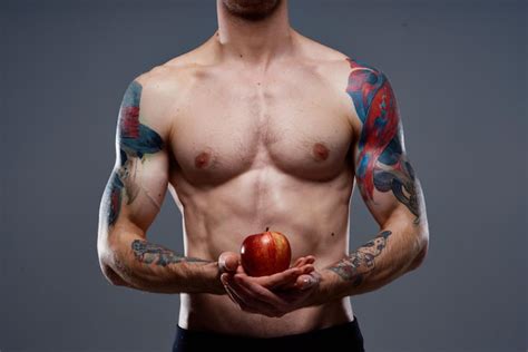 Premium Photo Man With A Tattoo Holds An Apple In His Hands Naked