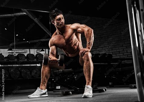 Handsome Muscular Man With Nude Body Uses His Dumbbell To Exerci Stock Photo Adobe Stock