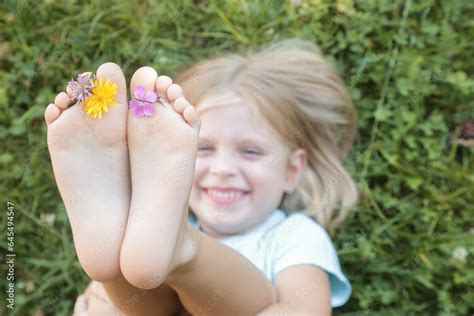 Child Feet On Green Grass Barefoot Little Girl On Meadow Countryside