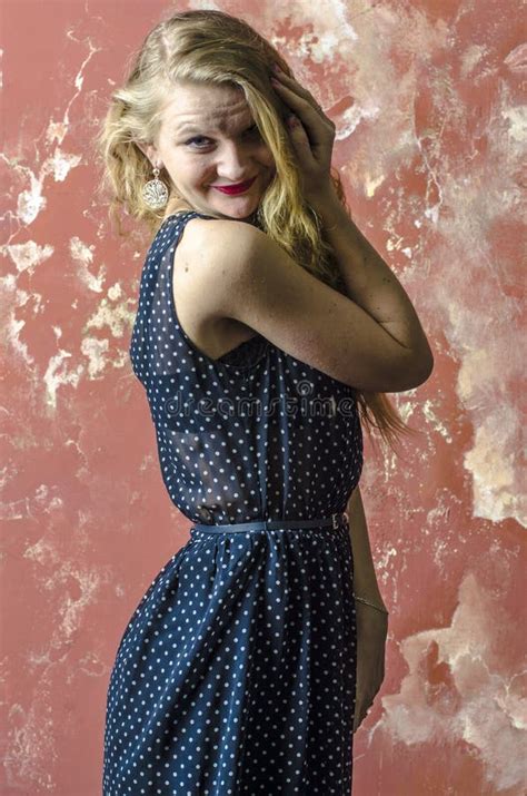 Jong Meisje Met Blonde Krullend Haar In Een Lange Kleding Met Stippen Met Teddybeer Stock Foto