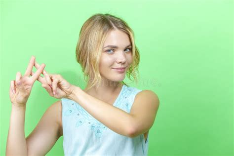 Jeune Fille Blonde Caucasienne Heureuse En Robe Bleue Posant En Tenant La Main Dans Le Geste Du