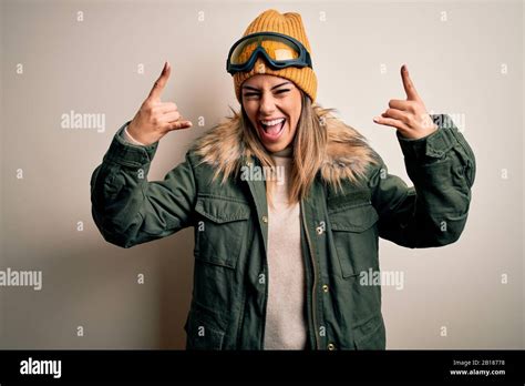 Junge Frau des Brunette Skifahrers Schneekleidung und eine Skibrille über weißem