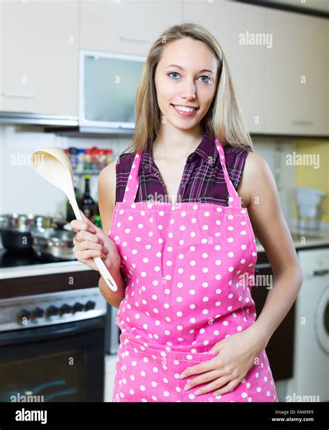 Portrait Of Cheerful Long Haired Blonde Girl In Apron Posing At Kitchen Stock Photo Alamy