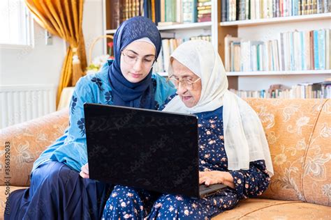 Happy Muslim Grandmother And Her Granddaughter Sitting Together On