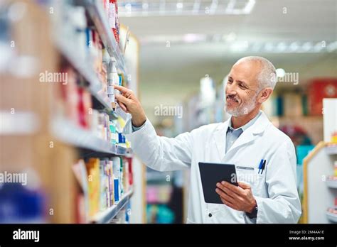 Making Sure The Shelves Stay Stocked A Handsome Mature Male Pharmacist Using A Tablet While