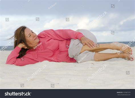 Portrait Of Pretty Looking Mature Woman Relaxed Exercising At Beach Keeping Healthy And Fit