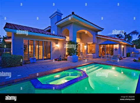 Illuminated swimming pool with Jacuzzi in front of luxury mansion Stock ...