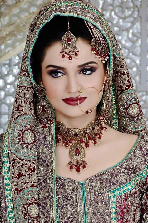 A Woman Wearing A Red And Green Bridal Outfit With Jewelry On Her Head