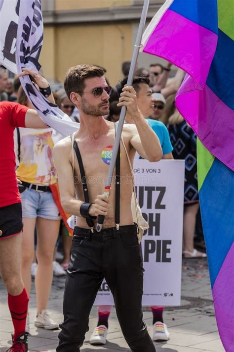 Muscled Handsome Man Holding A Large Rainbow Flag Attending The Gay Pride Parade Also Known As
