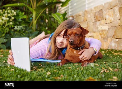 Blonde Junge M Dchen Selfie Foto Mit Tabletpc Und Hund Liegen Auf Dem Rasen Stockfotografie Alamy