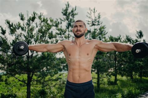 Premium Photo Healthy Man Stretches Weightlifting Biceps Exercises With Barbells Naked