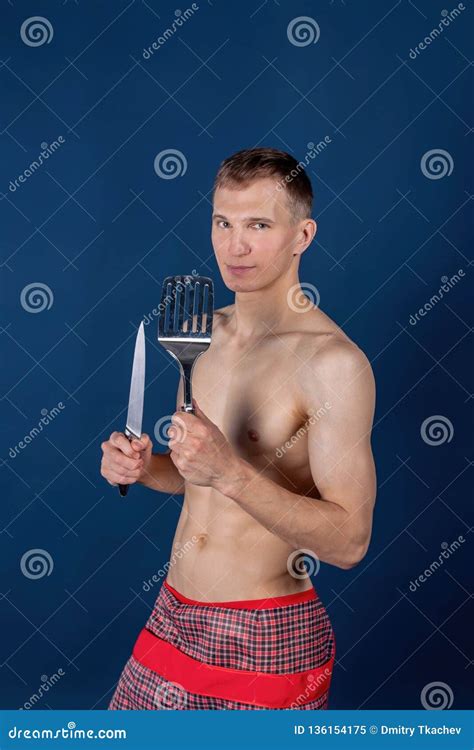 Handsome Chef With Apron On Naked Muscular Body With Knife And Kitchen Utensils Stock Image