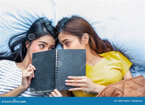 Cute Asian Lesbian Couple Reading Book Together And Lying On Bed Lifestyles And Lovers Concept