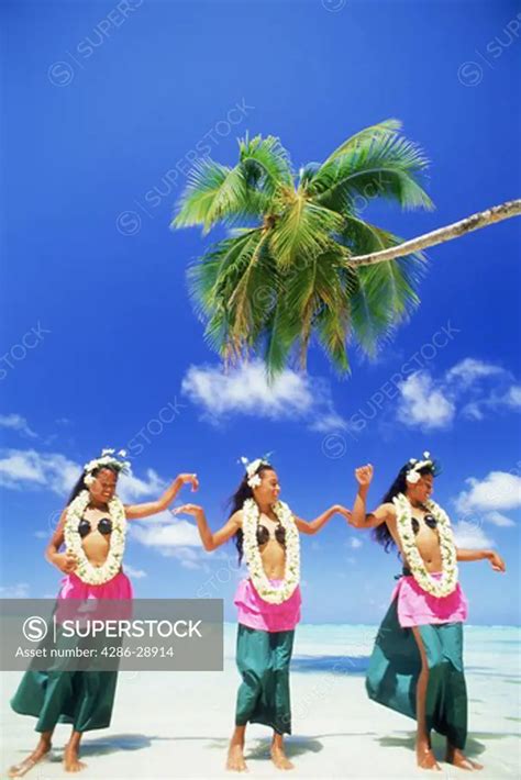 Three Polynesian Girls With Grass Skirts And Flower Leis On Aitutaki