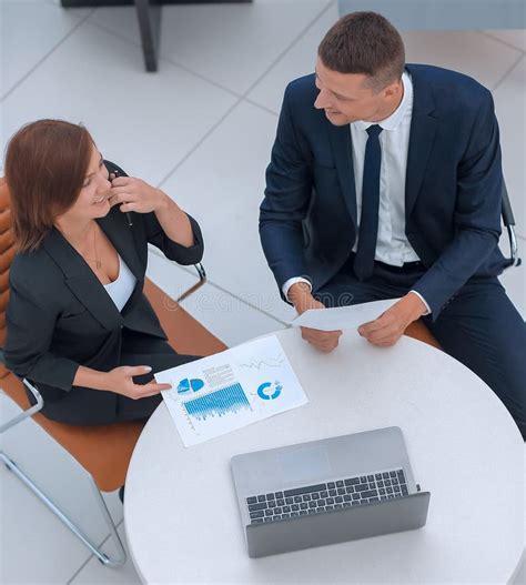 Businessman And Business Woman Discussing Marketing Scheme Stock Photo