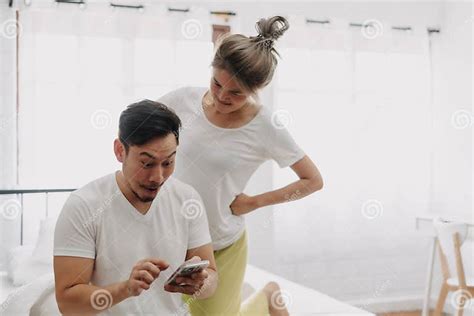 Funny Couple Wife Peeking Husband Who Chatting On The Smartphone