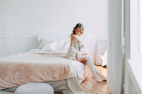 Premium Photo A Beautiful Sensual Young Woman In Lingerie And Cardigan Resting On The Bed