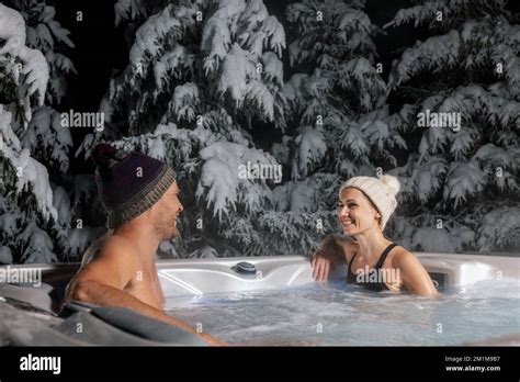 Happy Couple Relaxing In Outdoor Hot Tub At Winter With Snowy Trees In Background Spa Resort