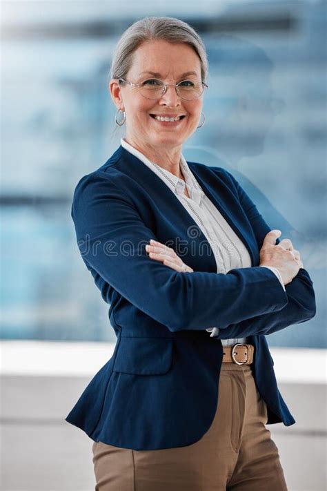 Im In Charge Around Here A Mature Businesswoman Standing Alone In The Office With Her Arms