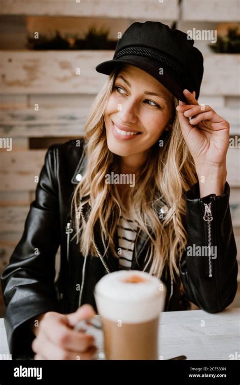 Long Haired Trendy Beautiful Blonde Woman Drinking From A Glass Of Delicious Foamy Coffee While