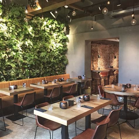 A Restaurant With Wooden Tables And Brown Leather Chairs Next To A Wall