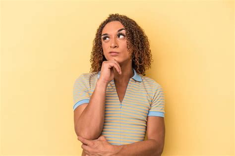 Jovem Transexual Latina Isolada Em Fundo Amarelo Pensando E Olhando Para Cima Sendo Reflexivo