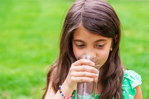 Premium Photo Children Drink Clean Water In Nature Selective Focus