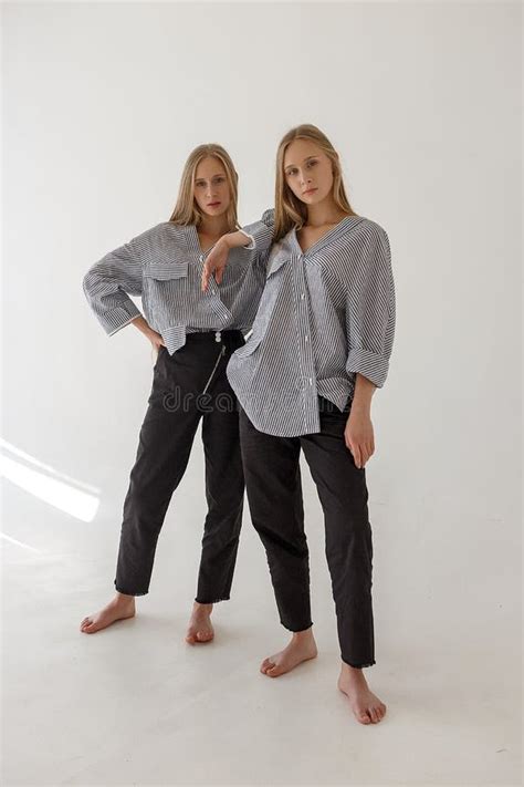 Twee Vrij Jonge Tweelingzusters Met Het Lange Blonde Haar Stellen Op Witte Achtergrond In