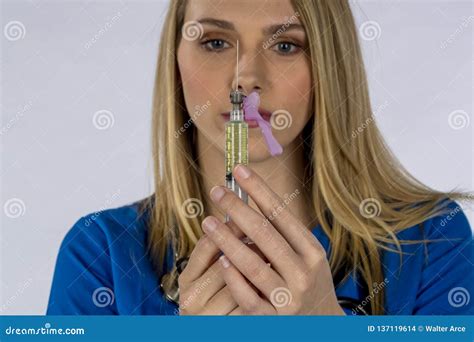 Heiße Blonde Krankenschwester Performing Her Duites Gegen Einen Weißen Hintergrund in Einer