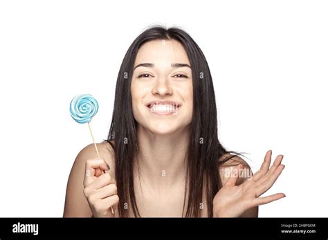 Studio Portrait Of A Beautiful Brunette Girl With Lollipop Against White Backgroung Stock Photo