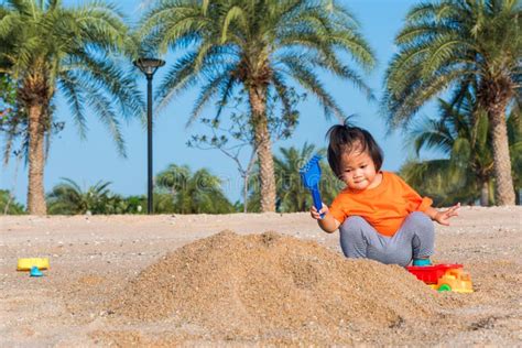 Cheerful Daughter Girl Funny Digging Playing Toy With Sand Stock Image