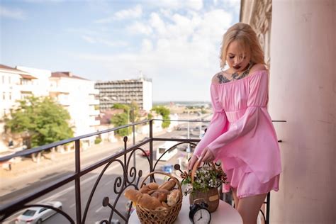 Belle femme blonde vêtue d une robe sexy rose avec un tatouage sur la poitrine se dresse sur un