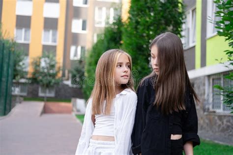 Fraternal Twins Sisters Blonde And Brunette Teen Girls In Fashionable Black And White Clothes