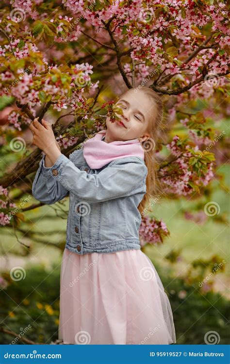 Une Fille Blonde Mignonne Sourit Sur Un Fond Des Bu Roses De Sakura Image Stock Image Du Beau