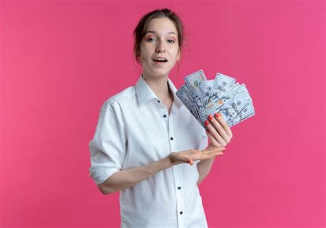 Jeune Fille Russe Blonde Heureuse Détient Et Points à L argent Sur Rose Avec Copie Espace