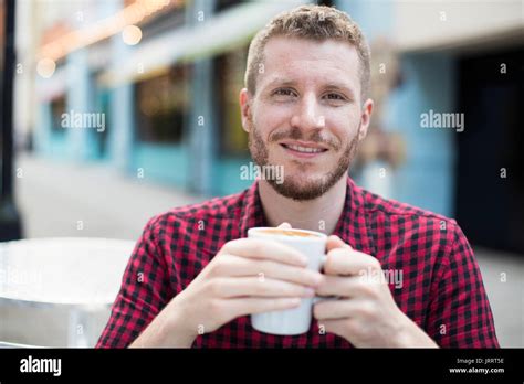 Portrait de jeune homme de boire du café au café en plein air le