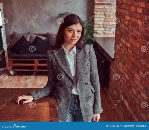 Portrait Of A Charming Brunette Woman Dressed In Trendy Clothes Posing In A Room With Loft