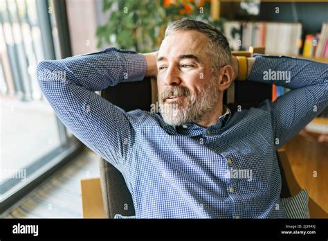 Nice Pensive Mature Man At Home Appartement With Grey Beard Relaxing On Chair Stock Photo Alamy