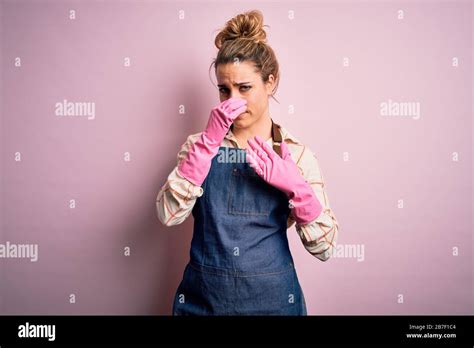 Junge schöne blonde Putzfrau Hausarbeit mit Arpon und Handschuhen macht etwas