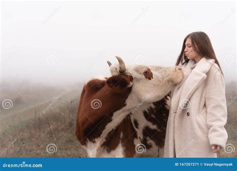 Aantrekkelijk Brunette Meisje In Witte Jas Blaast Een Kus Naar Een Koe Weide In Mist Op De
