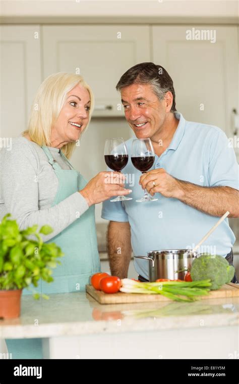 Happy Mature Couple Having Red Wine While Making Dinner Stock Photo Alamy